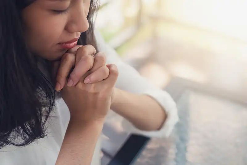 A photo of a woman praying.