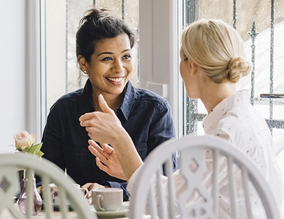 Two women friends enjoying a conversation over coffee.